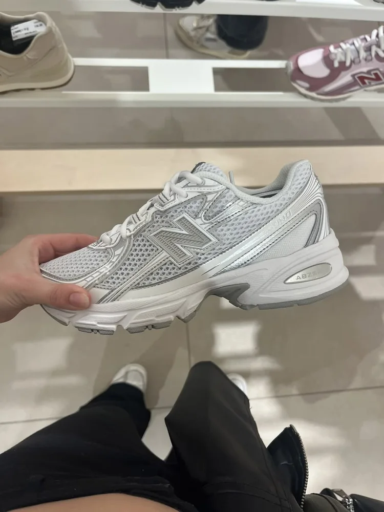 New Balance 530 White / Silver Metallic — Chaussures Oriol Shoes Abomey-Calavi. Basket basse blanche et grise, empeigne en mesh et empiècements synthétiques, logo latéral New Balance visible, semelle épaisse avec mention ABZORB