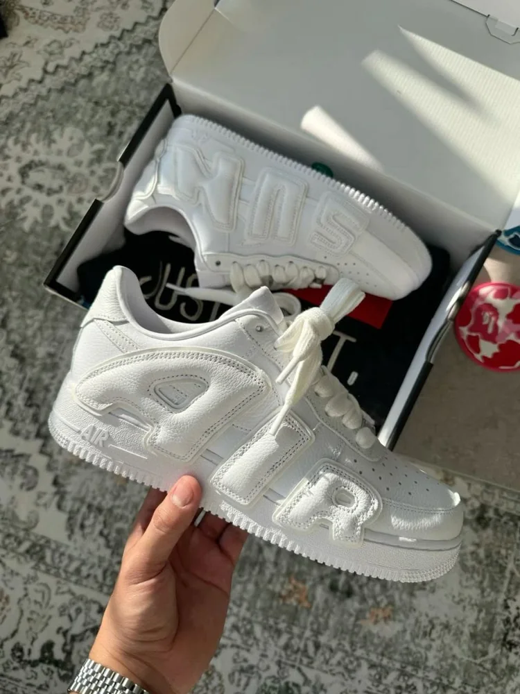 Nike Air Force 1 Low blanche à marquage AIR ton sur ton — Chaussures Oriol Shoes Abomey-Calavi. Basket basse entièrement blanche, empeigne en matière synthétique ou cuir non vérifiable, empiècements superposés, perforations à l’avant, lacets blancs, semelle épaisse blanche et marquage embossé de type « AIR » sur le côté